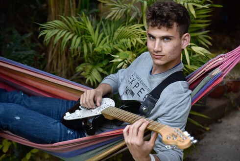 יהלי ברץ בן 14 מבית השיטה מנגן בגיטרה חשמלית. "כשאני עצוב או מתוסכל הגיטרה היא הדרך להירגע ולהשתחרר וגם להופיע ולתרום לקהילה"