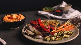 ירקות צלויים על מצע חומוס ועגבניות